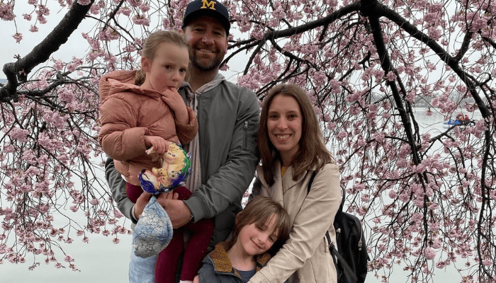Michigan LCV's Bentley Johnson with his wife, son, and daughter standing in front of cherry blossoms in Washington, D.C.